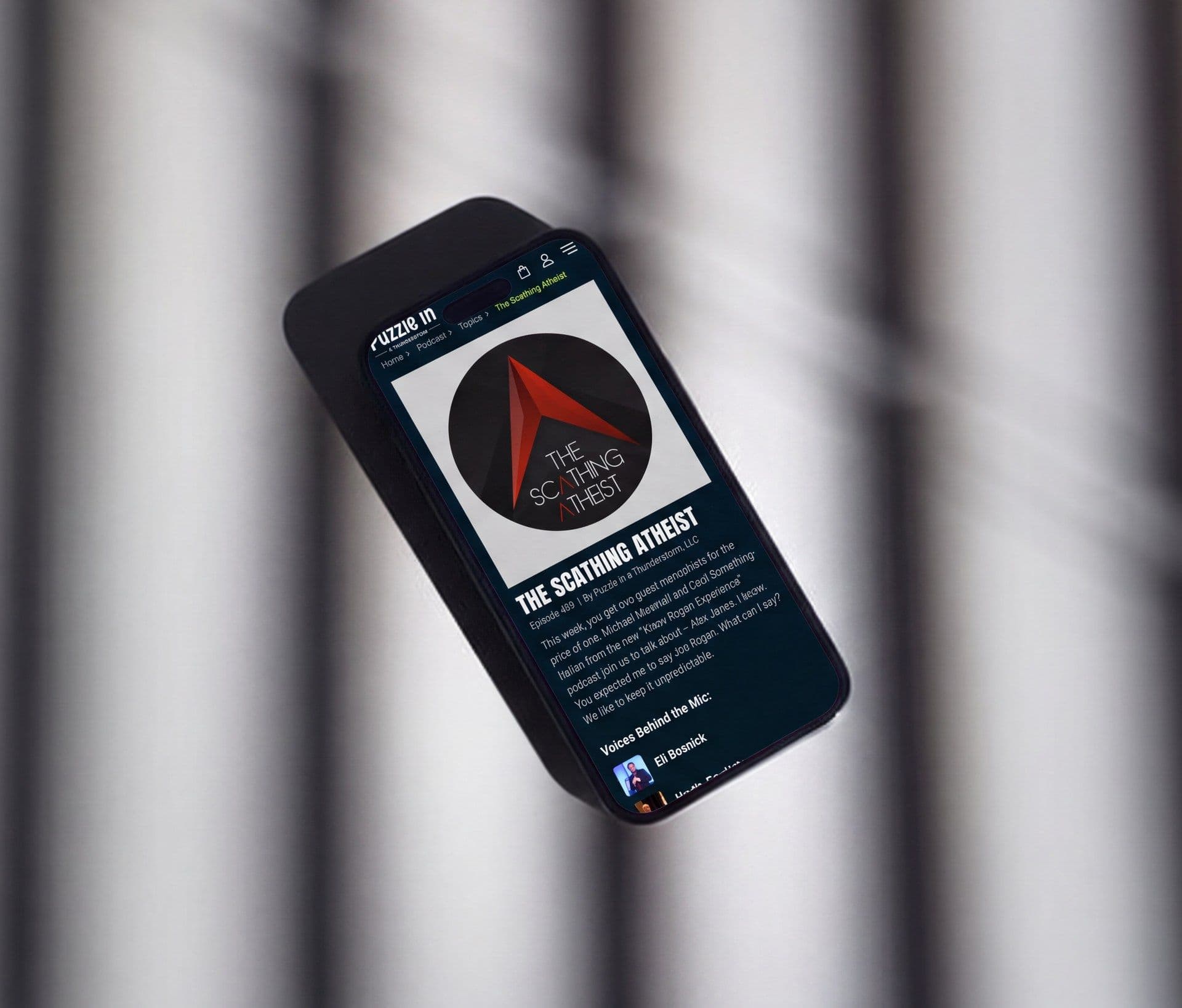 The same show page on a phone, held against the studio